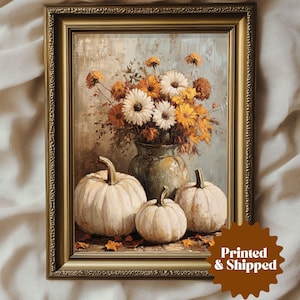 May include: A framed painting of a still life featuring a bouquet of yellow and white flowers in a vase and three white pumpkins. The painting is set against a light blue background.