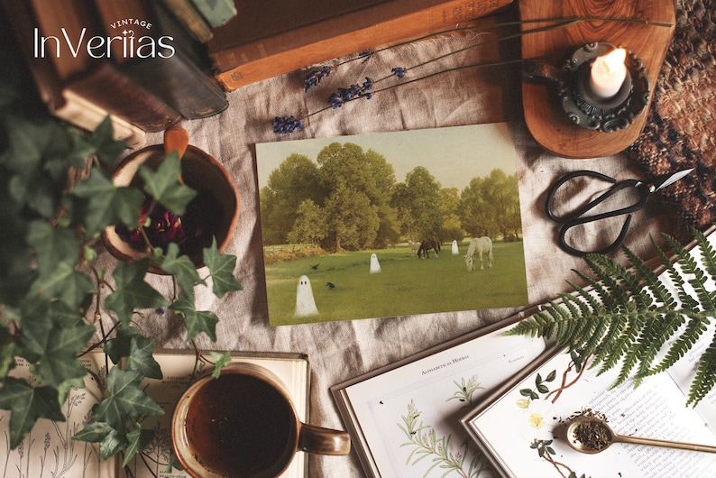 May include: A vintage postcard featuring a pastoral scene with horses grazing in a field, and several cartoon ghosts. The image is surrounded by books, a cup of coffee, a lit candle, and other decorative items. The word "Vintage" is at the top.