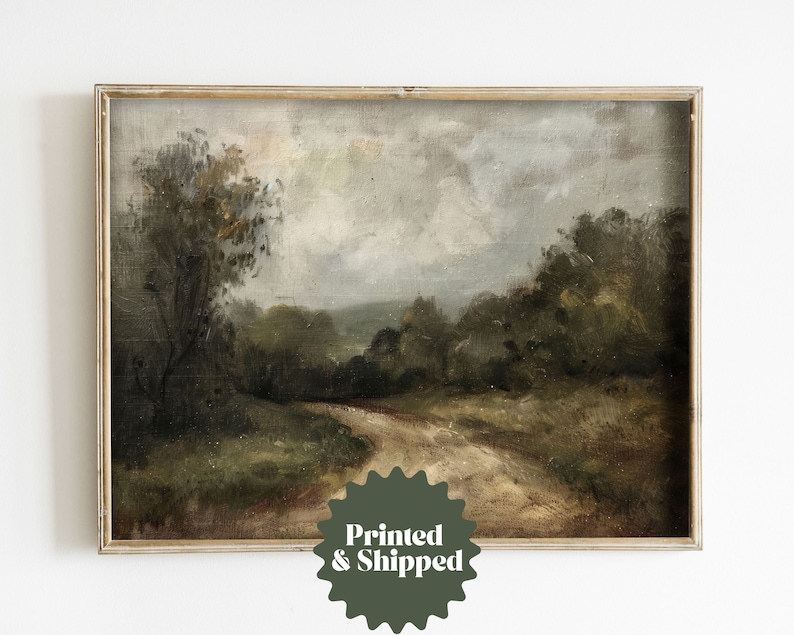 May include: A framed painting of a landscape with a dirt road winding through a forest. The sky is cloudy and the trees are a dark green. The painting is in a simple wooden frame.