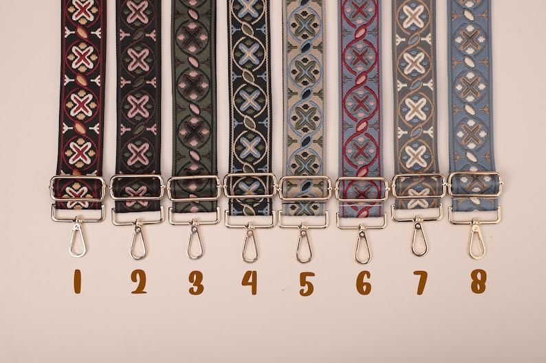 May include: Eight different patterned fabric straps with gold metal clasps and hooks. The straps are numbered 1 through 8.
