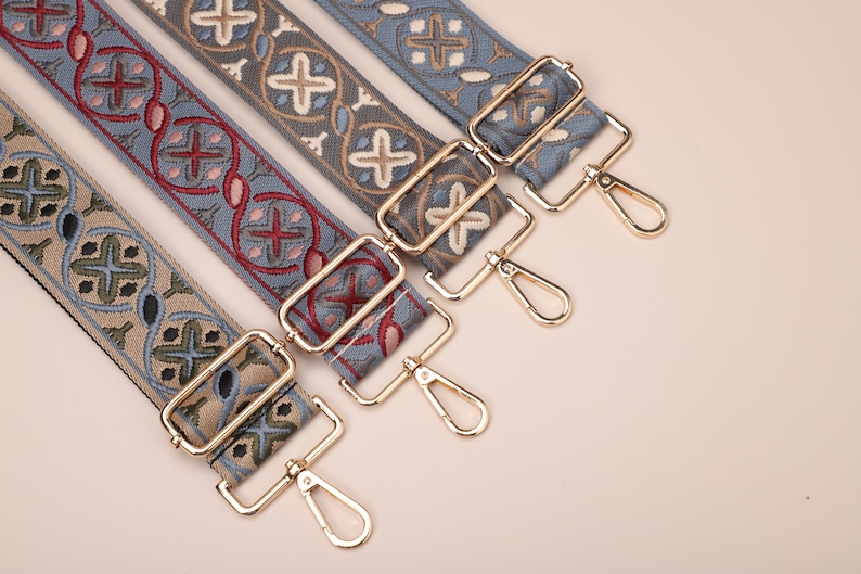 May include: Four patterned fabric straps with gold metal clasps. The straps are in shades of blue, green, and red.