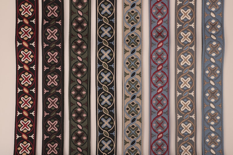 May include: Seven different patterned trim ribbons in various colors, including black, green, blue, and beige. The ribbons have a geometric design with repeating patterns.