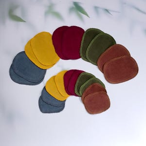 Könnte beinhalten: Ein Set mit 10 wiederverwendbaren Abschminkpads in verschiedenen Farben, darunter Gelb, Blau, Grün und Rot. Die Pads bestehen aus weichem, saugfähigem Stoff und eignen sich perfekt zum Entfernen von Make-up und zur Reinigung der Haut.