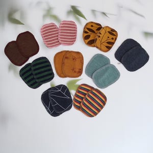 Könnte beinhalten: Ein Set mit 10 wiederverwendbaren Abschminkpads in verschiedenen Farben und Mustern, darunter gestreift, floral und einfarbig. Die Pads bestehen aus weichem, saugfähigem Stoff und sind so konzipiert, dass sie sanft zur Haut sind.