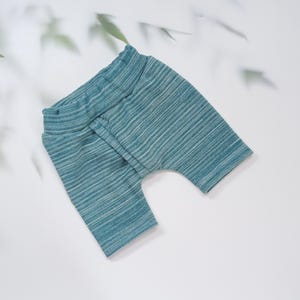 Pu&ograve; includere: Pantaloncini da bambino a righe turchese e bianche. I pantaloncini hanno un'ampia fascia in vita e una vestibilit&agrave; rilassata. Il tessuto ha un aspetto morbido e strutturato. I pantaloncini sono progettati per il comfort e la libert&agrave; di movimento.