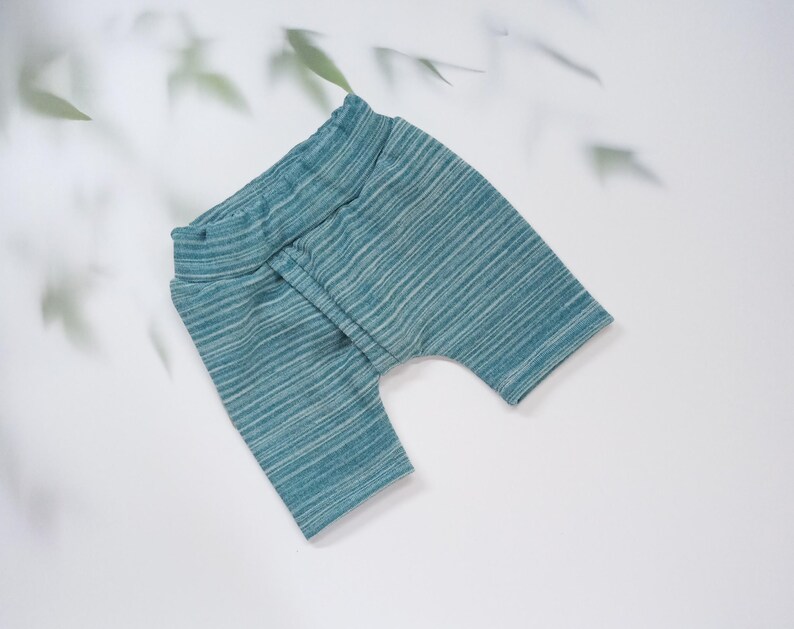 Pu&ograve; includere: Pantaloncini da bambino a righe turchese e bianche. I pantaloncini hanno un'ampia fascia in vita e una vestibilit&agrave; rilassata. Il tessuto ha un aspetto morbido e strutturato. I pantaloncini sono progettati per il comfort e la libert&agrave; di movimento.