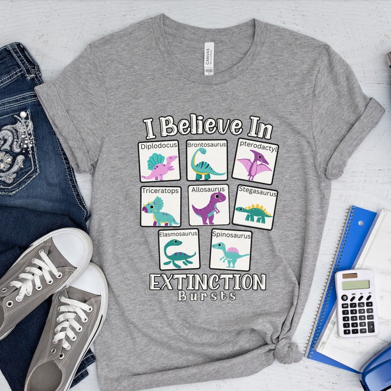 May include: Gray t-shirt with a graphic of dinosaurs and the text "I Believe In Extinction Bursts". The dinosaurs are in squares with their names below them. The dinosaurs are: Diplodocus, Brontosaurus, Pterodactyl, Triceratops, Allosaurus, Stegosaurus, Elasmosaurus, and Spinosaurus.