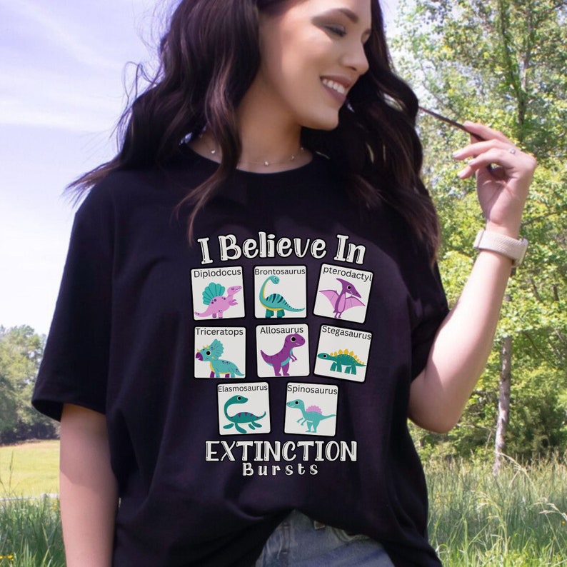 May include: Black t-shirt with a graphic of different dinosaurs and the text "I Believe In Extinction Bursts".