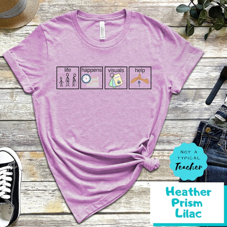 May include: A purple t-shirt with the text "life happens visuals help" and four illustrations in boxes. The text "Not a typical teacher" is in a circle with a white background and a teal border. The text "Heather Prism Lilac" is below the circle.
