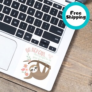 Peut inclure: Un autocollant blanc avec un paresseux de dessin animé suspendu à une branche, des fleurs roses et le texte "OH HEY GIRL don't forget to do your session notes". L'autocollant est sur un ordinateur portable.