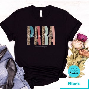 May include: Black t-shirt with the text "PARA education" in colorful letters with a leopard print pattern. The text "#Lifechanger" is below the main text. The shirt has a crew neck and short sleeves.