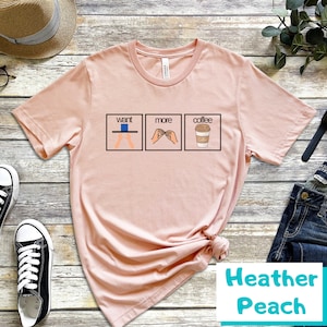 May include: A pink t-shirt with a graphic of three illustrations. The first illustration shows a person with their hands outstretched, the second illustration shows a person making a hand gesture, and the third illustration shows a cup of coffee. The text "want more coffee" is printed above the illustrations.