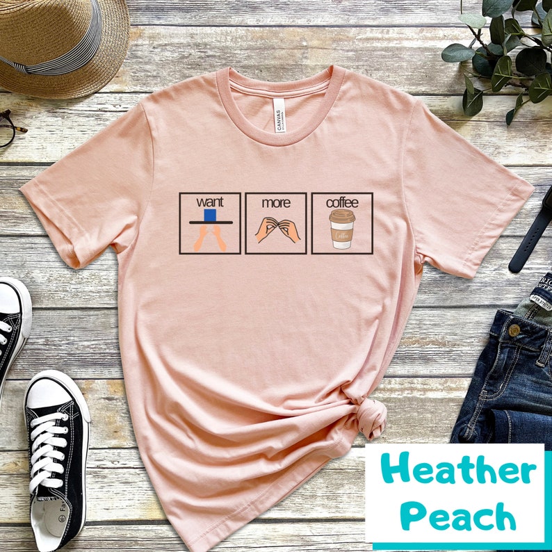 May include: A pink t-shirt with a graphic of three illustrations. The first illustration shows a person with their hands outstretched, the second illustration shows a person making a hand gesture, and the third illustration shows a cup of coffee. The text "want more coffee" is printed above the illustrations.