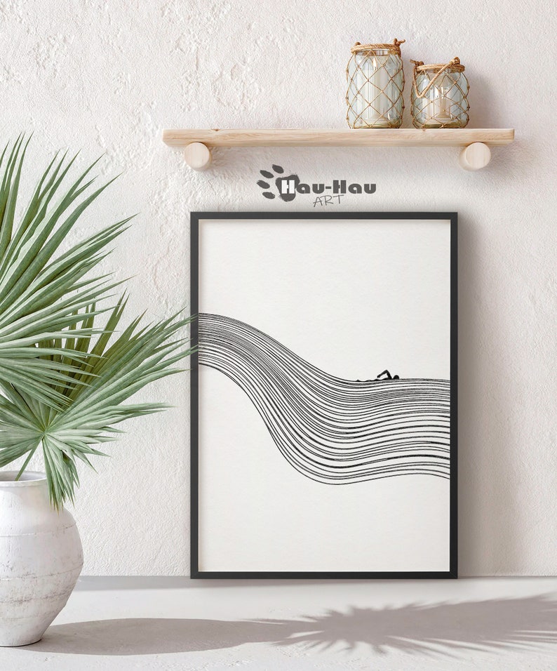 May include: Black and white line art print of a person swimming in a wave. The print is framed in a black frame and is hanging on a white wall.