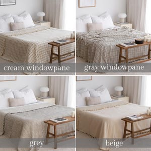 May include: Four different throw blankets on beds with white linens. The blankets are in cream windowpane, gray windowpane, gray, and beige. Each blanket has a fringe border.