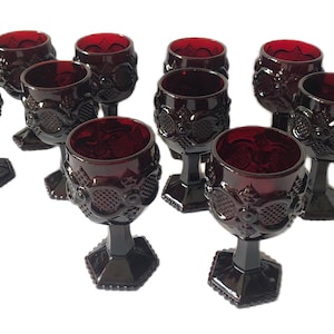 May include: Set of ten ruby red glass wine goblets with a textured design. The goblets have a round bowl and a stem with a hexagonal base.