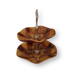 May include: Two-tiered wooden serving tray with a silver handle. The tray has a brown and gold woodgrain pattern.
