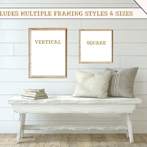 May include: Two wooden picture frames, one vertical and one square, are hanging on a white shiplap wall. The frames are empty and have a light brown finish. A white bench with a distressed finish sits in front of the frames. The bench has two cushions, one white and one grey with white stripes.
