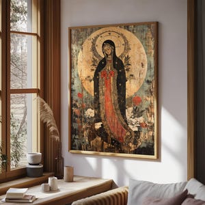 May include: A framed religious art print featuring a figure in a black robe with a red undergarment, set against a golden halo and a distressed background. The artwork is in a wooden frame, with floral accents, and is displayed in a room with natural light.