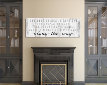 May include: A white wood sign with black text that reads "The best things in life are the people we love, the places we've been, and the memories we've made along the way."