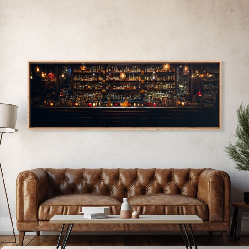 May include: A dimly lit bar with a long wooden counter and shelves stocked with bottles of liquor. The bar is illuminated by warm, yellow lights hanging from the ceiling.