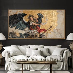 May include: A framed artwork depicting an angel with large black and teal wings, set against a gold sunburst background. The angel is clad in armor and a red sash, holding a staff. The artwork is displayed above a white sofa with pillows.