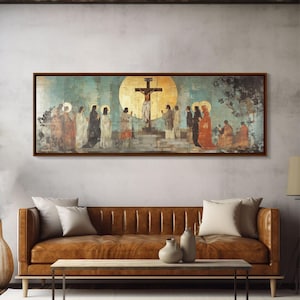 May include: A framed religious painting depicts a crucifixion scene with figures in robes and halos. The artwork features a large golden sun behind the cross, with a teal and gold background. The painting is displayed above a brown leather sofa.