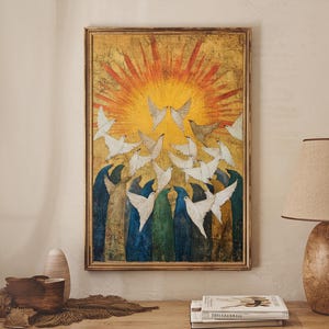May include: A framed artwork depicts white doves ascending towards a golden sunburst. The painting features a vibrant color palette with blues, greens, and yellows. The artwork is displayed on a wooden surface with a lamp and decorative items.