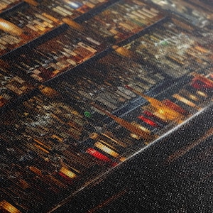 May include: A close-up of a wall of wine bottles, with the bottles arranged in rows and columns. The bottles are illuminated by a warm, golden light, creating a sense of depth and texture. The bottles are mostly red wine, but there are also some white and sparkling wines.
