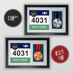 May include: A black frame with a white mat displays a runner's bib with the number 4031 and the name MARY THORNE. A silver medal is displayed in the second frame. The text "Framing Glory" is on the bib. The text "Offer" is in a black circle. The text "$25 Off" is in a red circle.