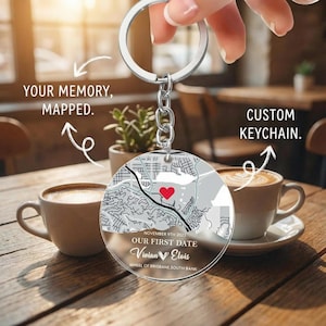 Puede incluir: Un llavero redondo y transparente con un diseño de mapa y un corazón rojo que marca una ubicación. El llavero incluye el texto "OUR FIRST DATE" y nombres, con las palabras "YOUR MEMORY, MAPPED" y "CUSTOM KEYCHAIN" en el fondo.