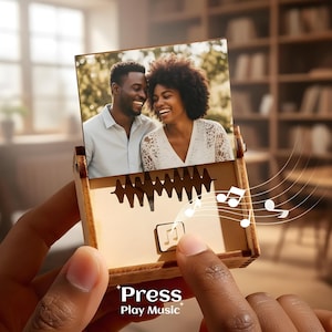 May include: A wooden music box with a photo of a smiling couple. The box has a sound wave design and musical notes. The text "Press Play Music" is at the bottom.