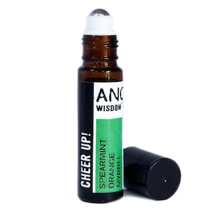 Può includere: Un flacone roll-on in vetro marrone con un tappo a sfera bianco e un tappo nero. L'etichetta recita "CHEER UP!" ed elenca "SPEARMINT ORANGE MYRRH". Il flacone è per aromaterapia e benessere.