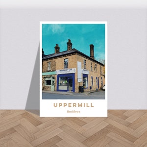 Puede incluir: Un edificio de ladrillo vintage con una fachada azul y el texto "J.W. Buckley Ltd. Bakery & Confectionery" sobre la entrada. El edificio tiene un letrero que dice "Uppermill Buckleys".