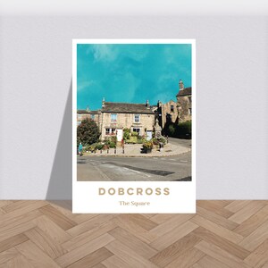 The Square Dobcross Saddlewertiger blauer Himmel Druck - Grafisches Dorf Plakat, bunte grobkörnige Wandkunst, mutiges Reise-Kunstwerk-Foto A6 - A2