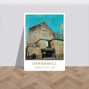 Puede incluir: Una postal de estilo vintage con un edificio de piedra con una torre del reloj y el texto "Uppermill Saddleworth Civic Hall". El edificio tiene una puerta verde y está situado contra un cielo azul.
