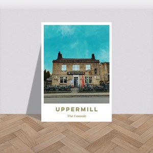 Puede incluir: Una ilustración de estilo vintage de un pub llamado "The Commie" en Uppermill, Inglaterra. El pub tiene una fachada de piedra con un letrero rojo y un cielo azul arriba.