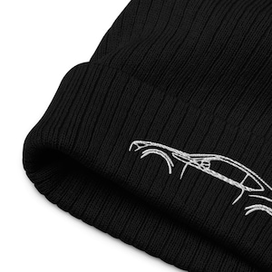 Peut inclure: Bonnet noir en tricot avec un contour de voiture brodé en blanc.