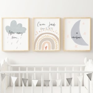 Puede incluir: Tres impresiones enmarcadas con un tema de guardería. La primera impresión presenta una nube gris con el texto "Después de cada tormenta," y gotas de lluvia. La segunda impresión presenta un arcoíris con el texto "Owen Jacob 11 de octubre de 2019." La tercera impresión presenta una luna creciente gris con el texto "un arcoíris."