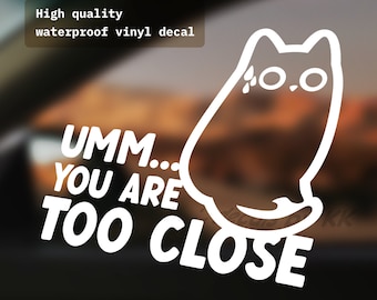 Puede incluir: Calcomanía de vinilo blanco con un gato de dibujos animados y el texto "UMM... YOU ARE TOO CLOSE" y el texto "*UPDATED VERSION!" en la parte inferior.