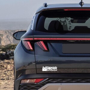 May include: A black SUV with a white cat sticker on the rear bumper that says "Why you gotta be so close".