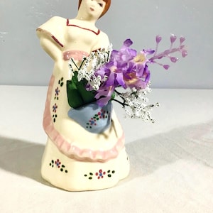 Niña con jarrón de cesta azul