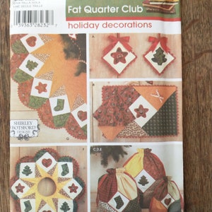 Könnte beinhalten: Simplicity-Schnittmuster 4414, Weihnachtsdekorationen des Fat Quarter Clubs. Das Schnittmuster enthält Anleitungen für die Herstellung eines Christbaumrockes, eines Tischläufers und Geschenktüten. Das Schnittmuster wurde von Shirley Botsford Designs entworfen.
