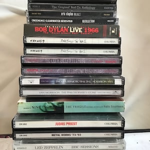 Puede incluir: Una pila de cintas de casete con varios artistas, incluyendo Bob Dylan, Pink Floyd, Jerry Garcia Band, Van Morrison, Nine Inch Nails, Judas Priest, Metal Works, Led Zeppelin, Lynyrd Skynyrd y Billy Squier.