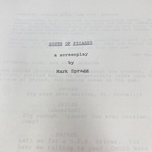 Puede incluir: Un guion impreso titulado "SOUTH OF PICASSO" de Mark Spragg. El texto está en negro sobre un fondo blanco. El guion es un documento antiguo, probablemente de una producción cinematográfica o televisiva.