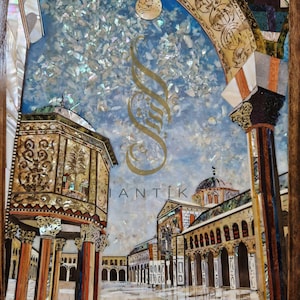 Può includere: Un'opera d'arte in mosaico che rappresenta una moschea con un minarete e un cortile. L'opera è realizzata in madreperla e altri materiali, creando un effetto scintillante. Il cielo è blu con nuvole bianche e un sole.