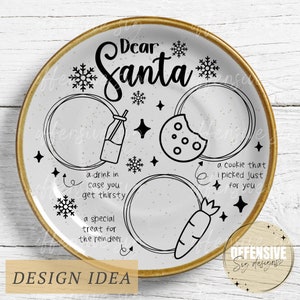 May include: A white ceramic plate with a gold rim, featuring a black and white illustration of a milk bottle, a cookie, a carrot, and snowflakes. The text "Dear Santa" is written in a decorative font. The plate has three circles with text inside: "a drink in case you get thirsty", "a special treat for the reindeer", and "a cookie that I picked just for you".