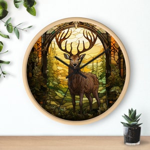 Op de afbeelding: Een klok van gekleurd glas met een hert dat in een bosomgeving staat. De wijzerplaat van de klok is omgeven door een houten frame.