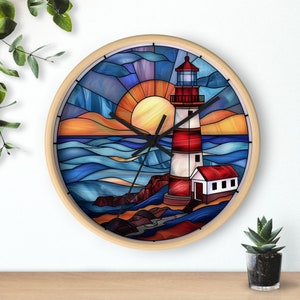 May include: A round clock with a stained glass design featuring a lighthouse, ocean waves, and a sunset. The clock face is white with black hands.