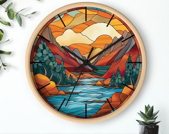 May include: A wooden clock with a stained glass design of a mountain landscape with a river flowing through it. The clock face is surrounded by a wooden frame.